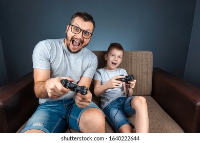 A Cheerful Family, Dad Mom And Son Play On The Console, Video Games, Emotionally React Sitting On The Couch. Day Off, Entertainment, Leisure, Spend Time Together