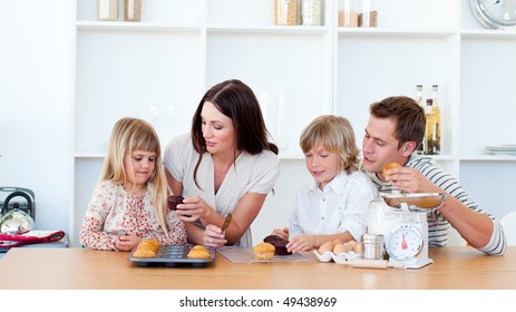 Cheerful Family Eating Muffins In The Kitchen At Home