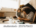 A cheerful family enjoys quality time bonding together while playing in a homemade blanket fort.