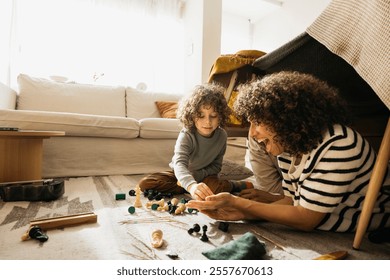 A cheerful family enjoys quality time bonding together while playing in a homemade blanket fort. - Powered by Shutterstock