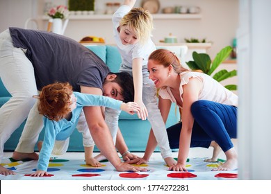 cheerful family having fun, playing twister game at home