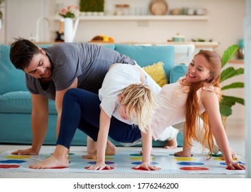 cheerful family having fun, playing twister game at home