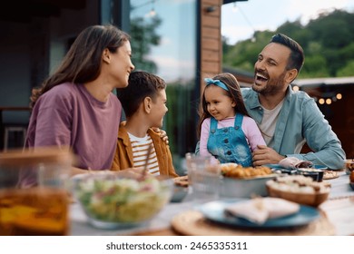 Cheerful family having fun while communicating during a meal on their terrace.  - Powered by Shutterstock