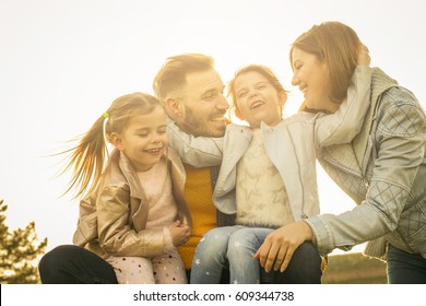 Cheerful Family Hugging Outdoor.