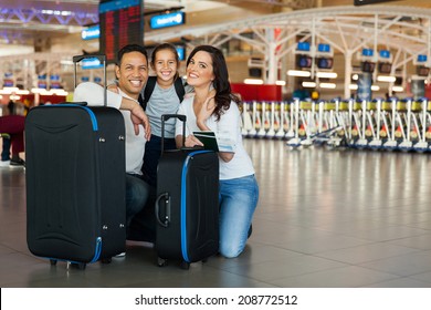 Cheerful Family With Luggage Bags At Airport