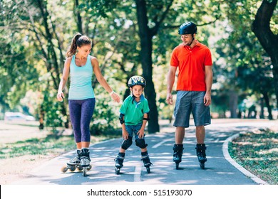 Cheerful Family Roller Skating In Park