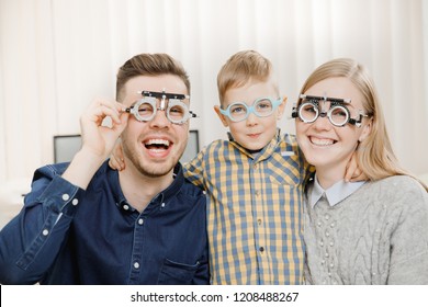 Cheerful Family With Small Child Reception Doctor Ophthalmologist Using Glasses, Eye Examination