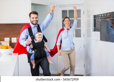 Cheerful Family In Superhero Costume With Baby At Home