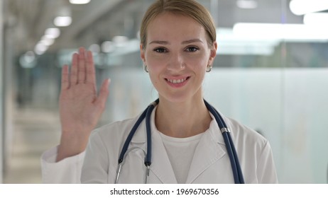 Cheerful Female Doctor Waving At The Camera 