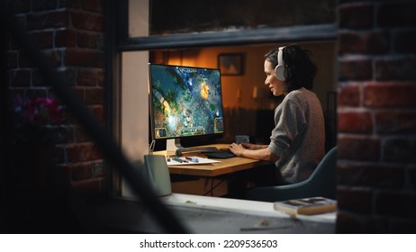 Cheerful Female Gamer Playing Online Video Game On Personal Computer. Professional Woman Player Enjoying Fantasy RPG. Real Role Playing Character Casting Magic Spells, Destroying Enemies. Window View.