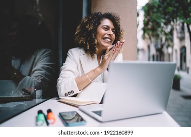 Cheerful female graphic designer feeling delight and happiness while doing remote work on laptop computer rejoicing at sidewalk cafe, joyful woman with netbook satisfied with freelance lifestyle - Shutterstock ID 1922160899