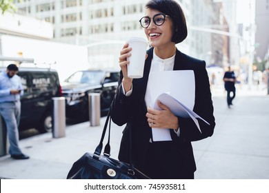 Cheerful Female Manager Getting To Work By Foot Drinking Morning Coffee To Go While Walking Street, Successful Businesswoman In Elegant Wear Enjoying Sunny Weather Strolling With Papers And Documents