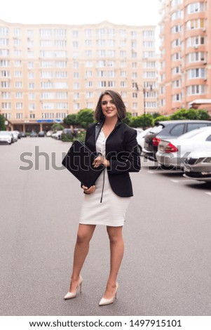 Cheerful female manager getting to work,  successful businesswoman wearing costume with papers and documents.