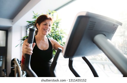 A Cheerful Female Senior In Gym Doing Cardio Workout.