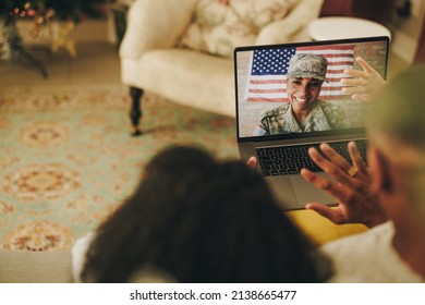 Cheerful Female Soldier Smiling Happily While Video Calling Her Husband And Children From The Military Base. American Military Family Communicating Online.