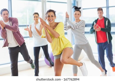 Cheerful Fitness Class And Instructor Doing Pilates Exercise In Bright Room