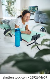 Cheerful Fitness Coach Recording The Workout Video For Her Online Audience From Her Home Gym