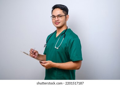 Cheerful Friendly Asian Male Physician, Doctor With Clipboard During Daily Checkup, Standing Over Isolated White Background