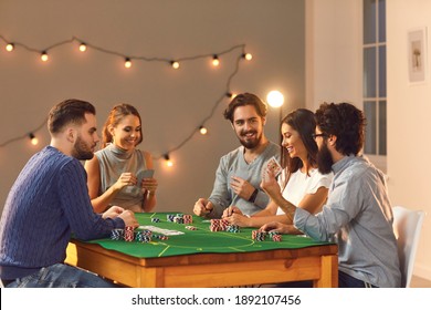 Cheerful Friendly Company Of Men And Women Sitting At A Poker Table And Enjoying The Game. Friends Play A Card Game At Home Or In A Club. Evening Entertainment Concept.