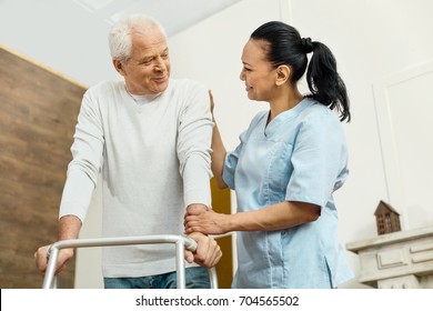 Cheerful Friendly Nurse Helping The Elderly Man