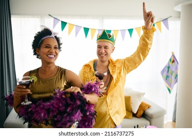 Cheerful Friends Drinking Cocktails And Dancing While Celebrating Mardi Gras At Home Party.