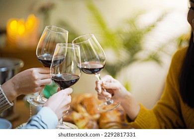 Cheerful friends enjoying home Birthday holiday party. Asian Friends cheering drinking red wine celebrating Christmas or New Year party. - Powered by Shutterstock