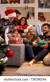 Cheerful Friends Exchanging Gift Boxes At Christmas Eve
