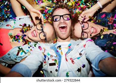 Cheerful friends lying on the floor in nightclub and making selfie - Powered by Shutterstock