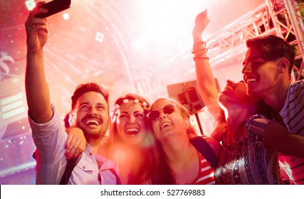 Cheerful friends partying in club at night - Powered by Shutterstock