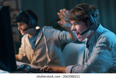 Cheerful Friends Playing Online Video Games Together And Winning, They Give A High Five