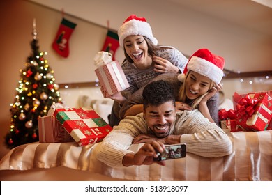 Cheerful Friends Taking A Christmas Selfie With Smartphone.