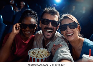 Cheerful friends taking selfie during 3D film projection in movie theater.  - Powered by Shutterstock