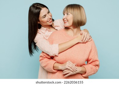 Cheerful fun satisfied elder parent mom with young adult daughter two women together wearing casual clothes hugging cuddle look to each other isolated on plain blue cyan background. Family day concept - Powered by Shutterstock