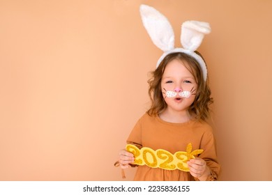 A cheerful funny surprised girl with an open mouth shouts in greeting to the new year 2023. A child disguised as rabbit is symbol of the year according to Chinese calendar - Shutterstock ID 2235836155