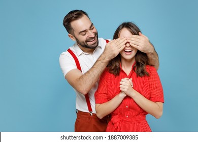Cheerful funny young couple friends man woman in white red clothes close eyes with hands, play guess who or hide and seek isolated on blue background studio portrait. Valentine's Day holiday concept