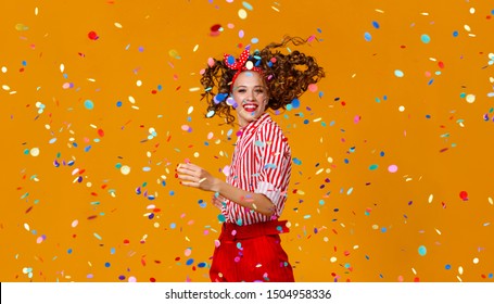 Cheerful Funny Young Woman With Festive Confetti On Yellow Background
