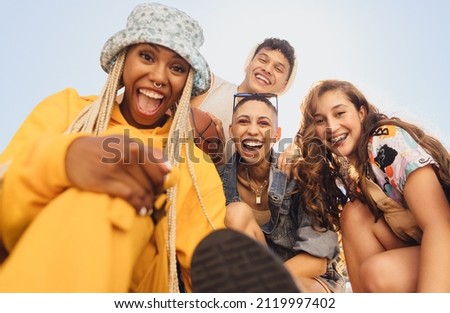 Cheerful generation z friends having fun together outdoors. Group of multiethnic friends smiling at the camera cheerfully. Vibrant young people making happy memories together. 商業照片 © 