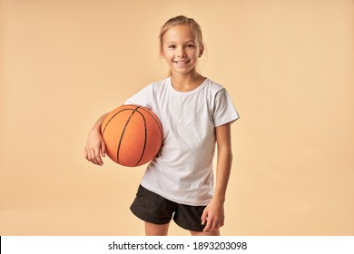 Cheerful girl basketball player holding game ball