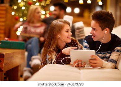 Cheerful girl and boy listening music on tablet together