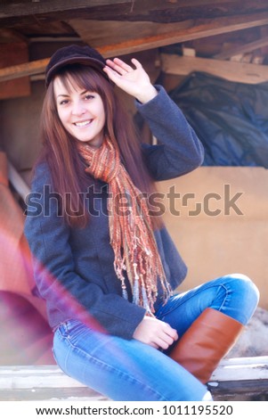 Cheerful girl in a cap sitting on a bench