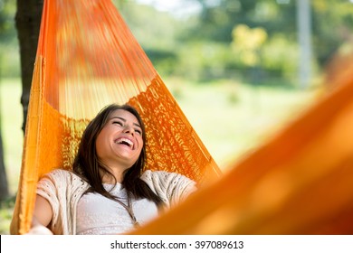Cheerful girl enjoy in orange hammock outdoor