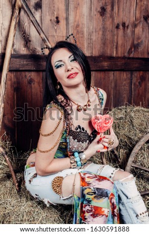 Cheerful girl in the hay. In jeans. Emotions