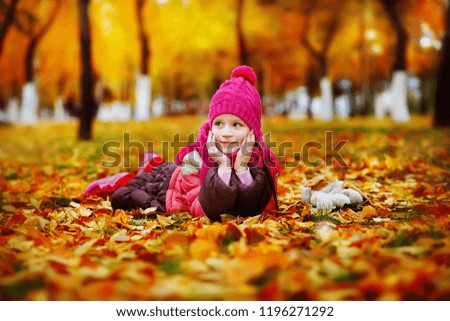 Herbstportrait eines lächelnden Kindmädchens mit Blumenstrauß aus Blättern