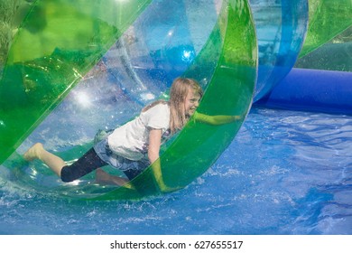 Cheerful Girl Playing In An Inflatable Plastic Balloon On The Water