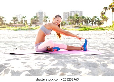 cheerful girl working out on the beach. fitness instructor making exercise.