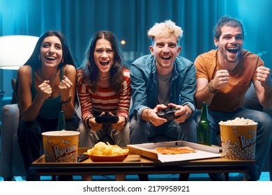Cheerful group of friends playing video games together at home, leisure and entertainment concept