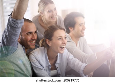 Cheerful Group Of Friends Watching Football Game On Tv