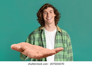 Cheerful guy in casual outfit outstretching big hand at camera and smiling, holding or asking for something, posing over turquoise studio background, copy space, creative image - Shutterstock ID 2075034370