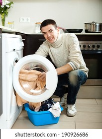 Cheerful Guy  Doing Laundry With Washing Machine At Home