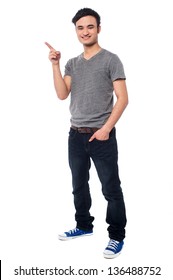 Cheerful Guy Pointing At Something Interesting, Full Length Portrait.